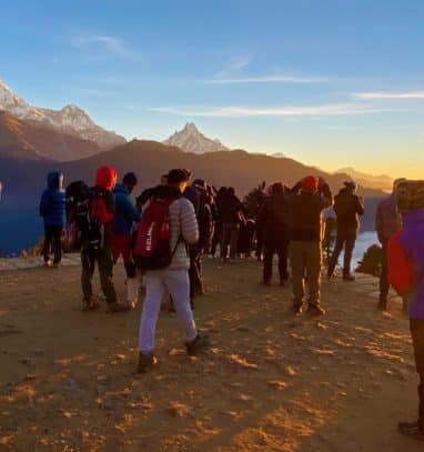 a group of trekkers watching sunrise in morning with mountains views from Poon hill station after a successful ghorepani poonhill trek